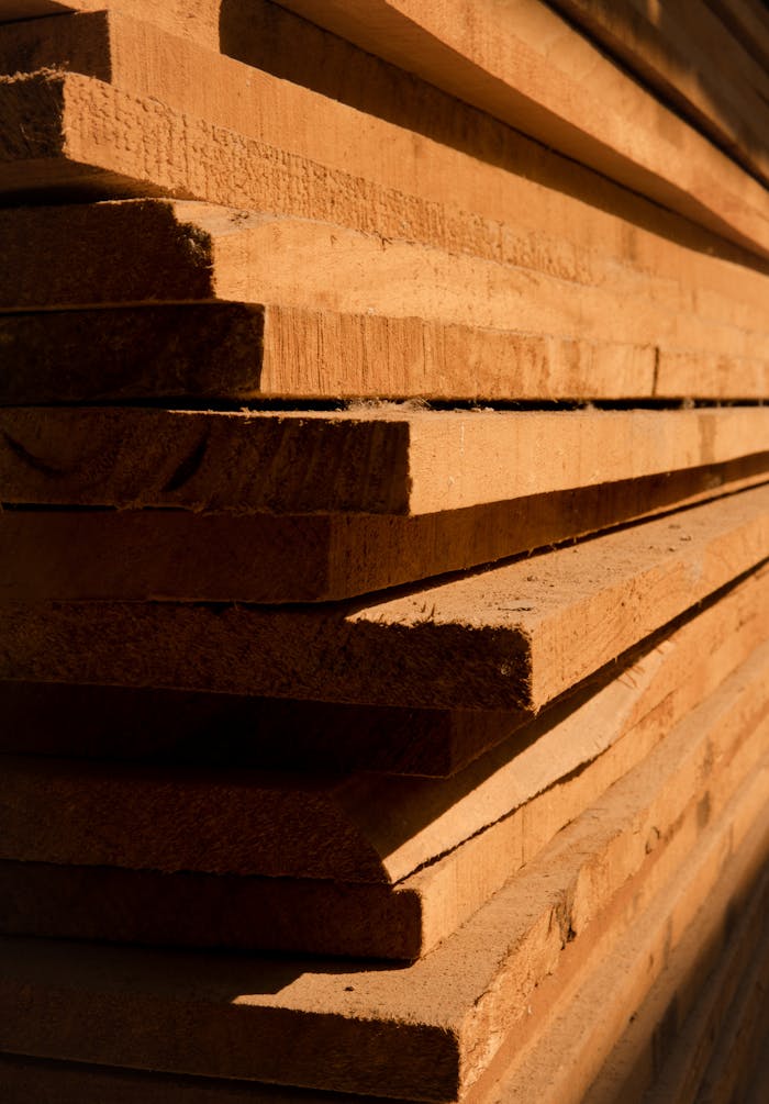 Close-up view of stacked wooden planks showcasing texture and sunlight shadows.